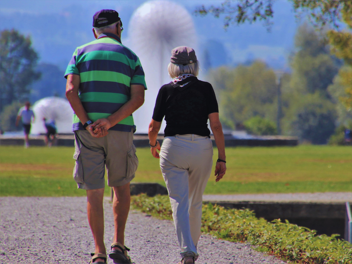 anziani che passeggiano in estate su un giardino