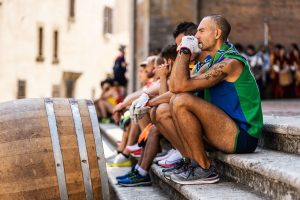 Bravio spingitori seduti sul selciato del Duomo con davanti le botti