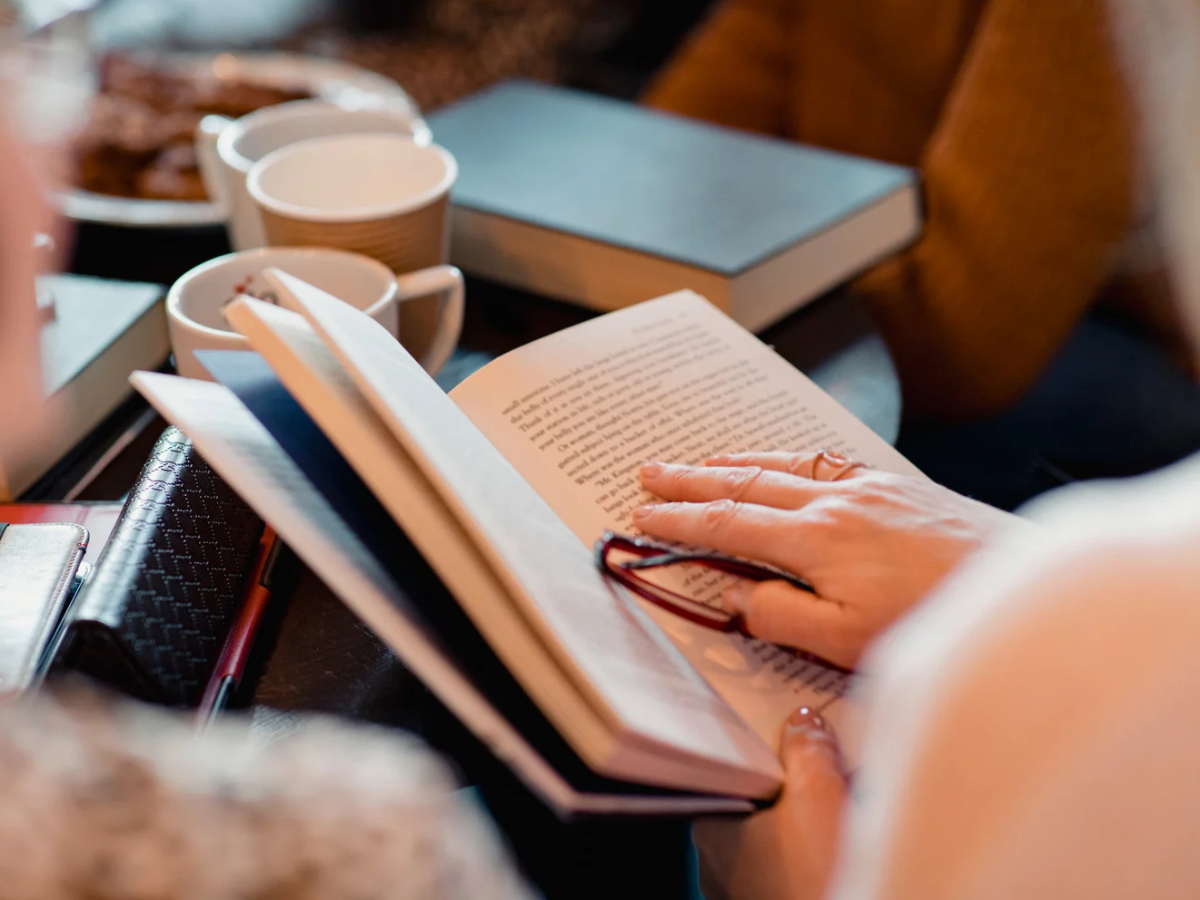 Libro aperto con persona intenta a leggerlo